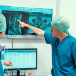 Caspar Aylott spinal surgeon and colleague examining an x-ray pre-surgery