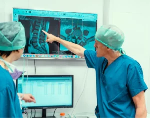 Caspar Aylott spinal surgeon and colleague examining an x-ray pre-surgery