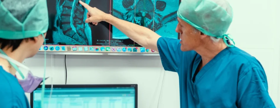 Caspar Aylott spinal surgeon and colleague examining an x-ray pre-surgery